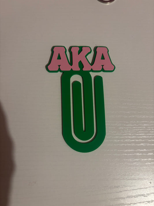 Pink and green AKA paperclip bookmark with pink raised letters on top and green paperclip shape below